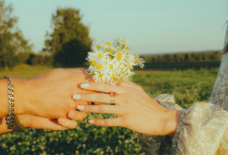 Літній квітковий манікюр з білими ромашками на фоні природи, романтична фотосесія на заході сонця