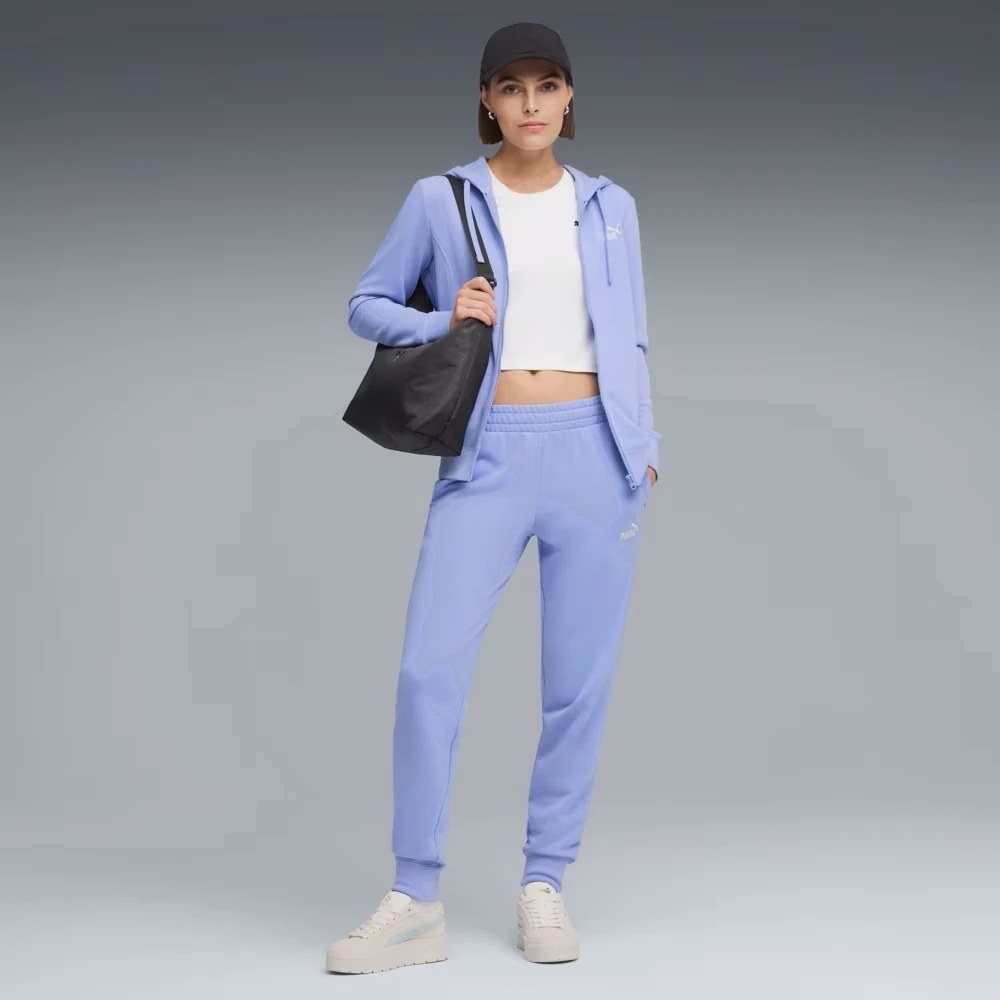 жінка в блакитному спортивному брючному костюмі та білій футболці
